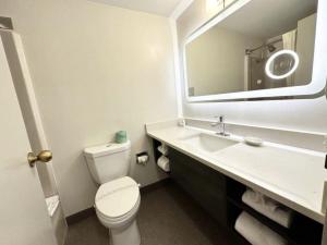 a bathroom with a toilet and a sink and a mirror at Kiteville Cedar Rapids in Cedar Rapids