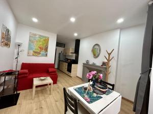 a living room with a red couch and a table at Cathedral: Cosy in the heart of the city center in Poitiers