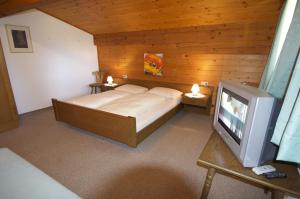 Schlafzimmer mit einem Bett und einem TV in der Unterkunft Dreiländerhaus in Westendorf