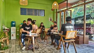 un grupo de personas sentadas en mesas en un restaurante en 80 Bar Hostel en Corón