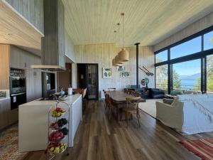 a kitchen and a living room with a table at Casa Flor del Lago in Villarrica