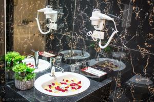 a bathroom with two sinks with flowers in it at Lotus Hotel - A24, Khu Đấu Giá, Vạn Phúc - by Bay Luxury in Hà Ðông +16 photos