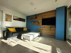 ein Wohnzimmer mit einem Sofa und einem TV an der Wand in der Unterkunft Appartement Palavas-les-Flots, 2 pièces, 5 personnes - FR-1-715-89 in Palavas-les-Flots