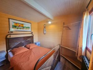 ein kleines Schlafzimmer mit einem Bett in einem Zimmer mit Holzwänden in der Unterkunft Gîte Saint-Germain-Lespinasse, 2 pièces, 4 personnes - FR-1-496-308 in Saint-Germain-Lespinasse