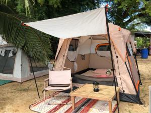 ein Zelt mit einem Stuhl und einem Tisch davor in der Unterkunft Malee homestay in Ko Por
