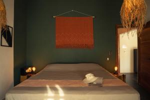 ein Bett in einem Schlafzimmer mit einer grünen Wand in der Unterkunft Casa MexiBali, Suite Mexi in Troncones
