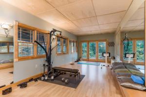 Habitación con gimnasio con sofá y cinta de correr en Spacious Lakefront Retreat w/Stunning Views 