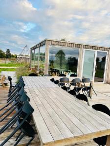 una gran mesa de madera y sillas en una terraza en Prześpij się z Alpaką w Tiny House, 