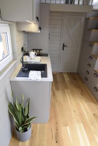 a small kitchen with a sink and a door at Prześpij się z Alpaką w Tiny House 