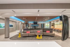 a hotel lobby with a couch and a bar at SpringHill Suites Dallas Central Expressway in Dallas