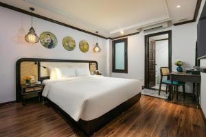 a bedroom with a large white bed and a desk at Media Central Hanoi Hotel - 108 Hàng Bạc - by Bay Luxury in Hanoi