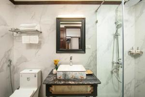 a bathroom with a sink and a toilet and a mirror at Media Central Hanoi Hotel - 108 Hàng Bạc - by Bay Luxury in Hanoi