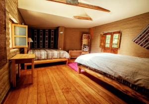 a bedroom with a bed and a wooden floor at Alojamiento Casa Yanantin de Maravilca in Concepción