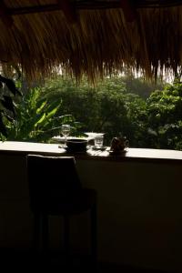 a table with a plate of food and a chair in front of a window at Casa Mexibali, Suite Bali in Troncones +28 photos