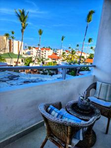 a balcony with a table and chairs and palm trees at Beach Sun Caribbean and Ducassi in Punta Cana