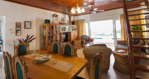uma sala de jantar com uma mesa e uma televisão em Ocean Villa em Grand'Anse Praslin