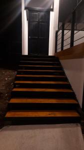 a set of stairs leading to a black door at Mon Bellis in El Copey