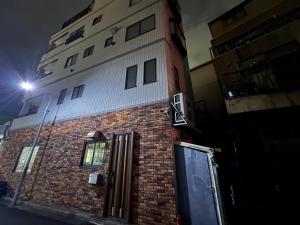 a tall brick building with a door in front of it at S-asakusa in Tokyo