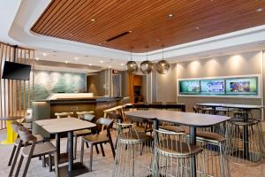 a restaurant with tables and chairs and a bar at SpringHill Suites by Marriott Ocala in Ocala