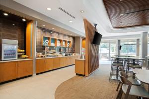 a restaurant with a bar and tables and chairs at SpringHill Suites by Marriott Ocala in Ocala