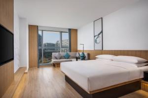 - une chambre avec un grand lit et un canapé dans l'établissement Fairfield by Marriott Hangzhou Xintiandi, à Hangzhou