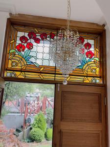a chandelier hanging over a door with a stained glass window at Handcrafted stained-glass cottage, free parking in Hobart