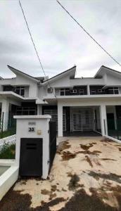 a large white house with a garage in front of it at Nurul Homestay Ajil in Bukit Payong