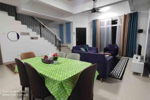 a living room with a table and a couch at Nurul Homestay Ajil in Bukit Payong