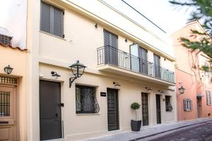 a building with black shutters on a street at Athens Muses Suites in Athens