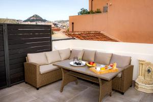 eine Terrasse mit einem Sofa und einem Tisch auf dem Balkon in der Unterkunft Athens Muses Suites in Athen