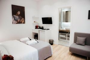 um quarto branco com uma cama e uma cadeira em Athens Muses Suites em Atenas