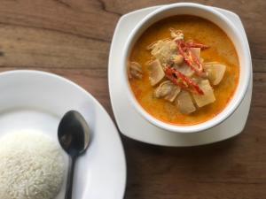 a bowl of soup next to a plate of rice at Ample Forest Khao Sok Farmstay 
