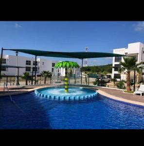una piscina con una palma al centro di Departamento Azul Marino Cerritos a Mazatlán