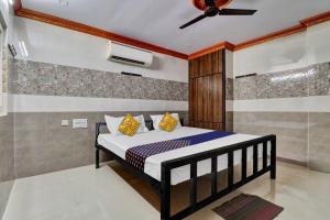 a bedroom with a bed and a ceiling fan at SPOT ON Hotel Maha Lakshmi in Ongole