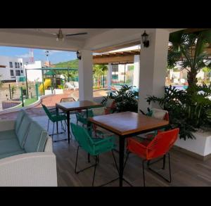 un patio con tavoli, sedie e divano di Departamento Azul Marino Cerritos a Mazatlán