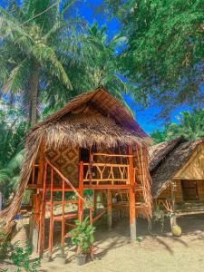 a hut on the beach with a palm tree at Malee homestay in Ko Por