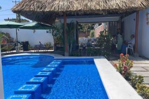 - une piscine avec des chaises et un parasol dans l'établissement Casa AbrahamMya Playa Linda 3 bed home with pool., à El Desengaño
