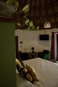 una camera da letto con un letto con cuscini sopra di Casa MexiBali, Palapa Queen a La Majahua