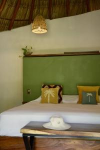 una camera da letto con un grande letto con una parete verde di Casa MexiBali, Palapa Queen a La Majahua