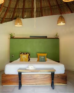 una camera da letto con un grande letto con una parete verde di Casa MexiBali, Palapa Queen a La Majahua