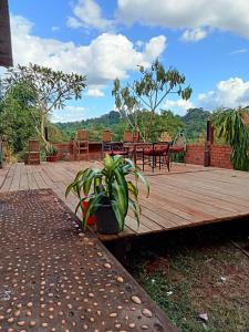 een houten terras met een tafel en stoelen bij Green Hill Homestay, Restaurant & Treķking in Banlung