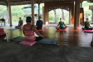 a group of people sitting in a yoga class at Alaya Ecolodge in Pemuteran