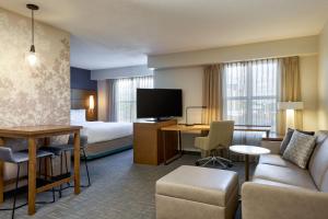 um quarto de hotel com uma cama e uma sala de estar em Residence Inn by Marriott Greenbelt em Greenbelt