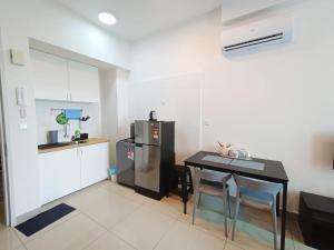 Il comprend une petite cuisine équipée d'une table et d'un réfrigérateur. dans l'établissement Plaza at Kelana Jaya By Kenangan Home 2 Bedroom Balcony, à Petaling Jaya