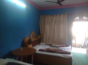 a bedroom with a bed and a table and a window at Hotel diyaraj barkot sarukhet in Barkot