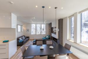 a dining room and living room with a table and chairs at Owl House Niseko in Niseko