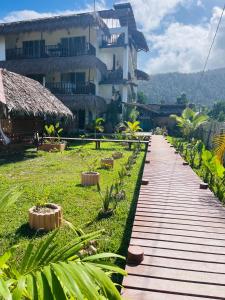 una pasarela de madera frente a un edificio en La Palapa Inn Port Barton, en San Vicente