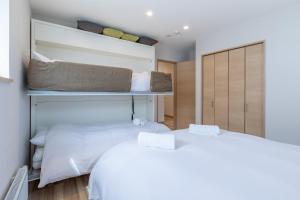 1 dormitorio con 2 camas y armario en Owl House Niseko, en Niseko