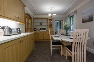 a kitchen with a table and chairs and a kitchen with a counter at Spacious bungalow with estuary views in Carmarthen