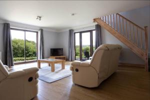 a living room with two chairs and a table at Spacious bungalow with estuary views in Carmarthen